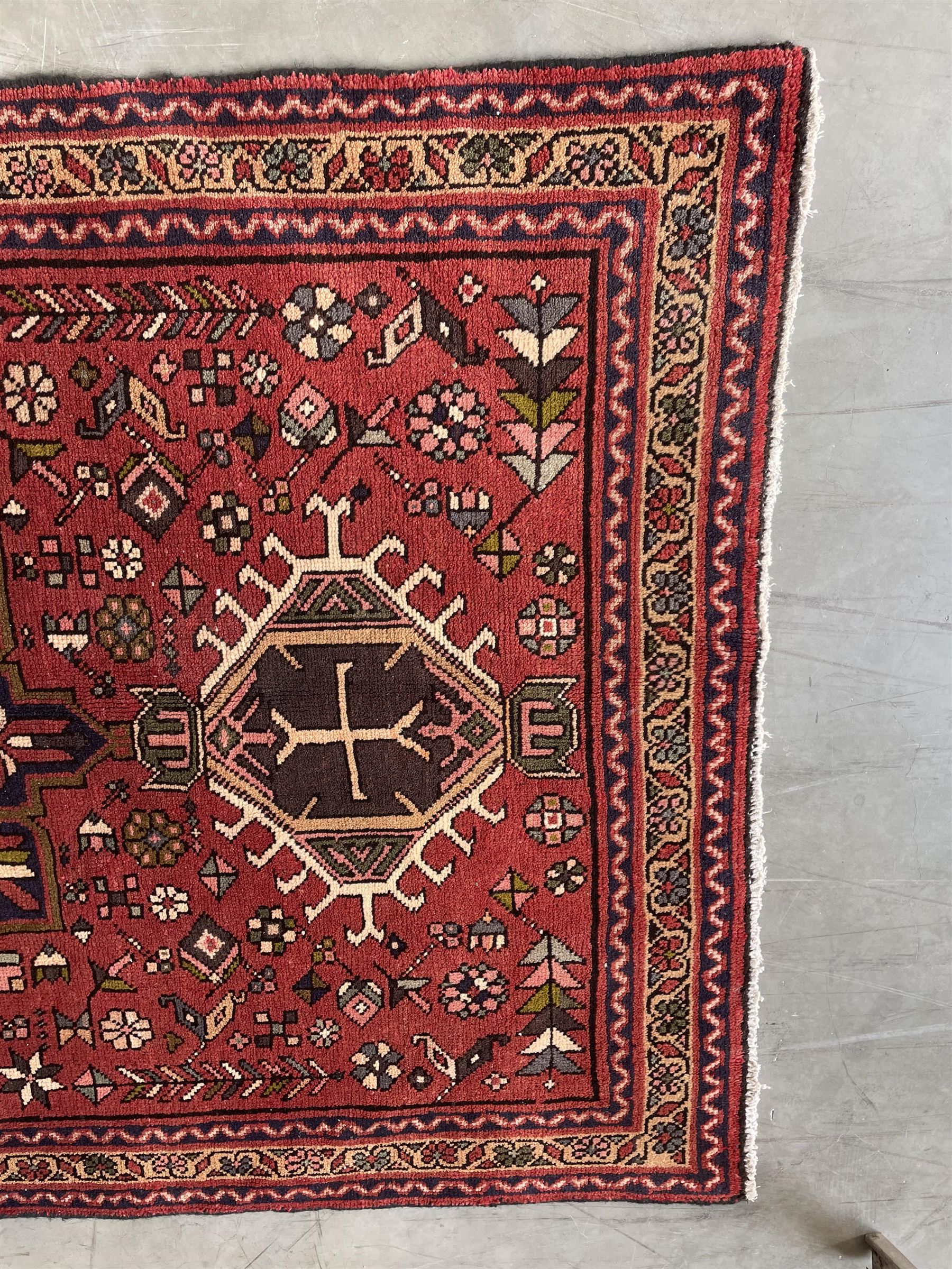 Persian Karajeh red ground runner, decorated with multiple stylised medallions and motifs