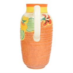 Clarice Cliff Nasturtium jug, shape Greek 563, hand painted with a band of stylised flowers and foliage over a stippled brown ground with orange and yellow banding to the spout,  Bizarre mark beneath, H23cm