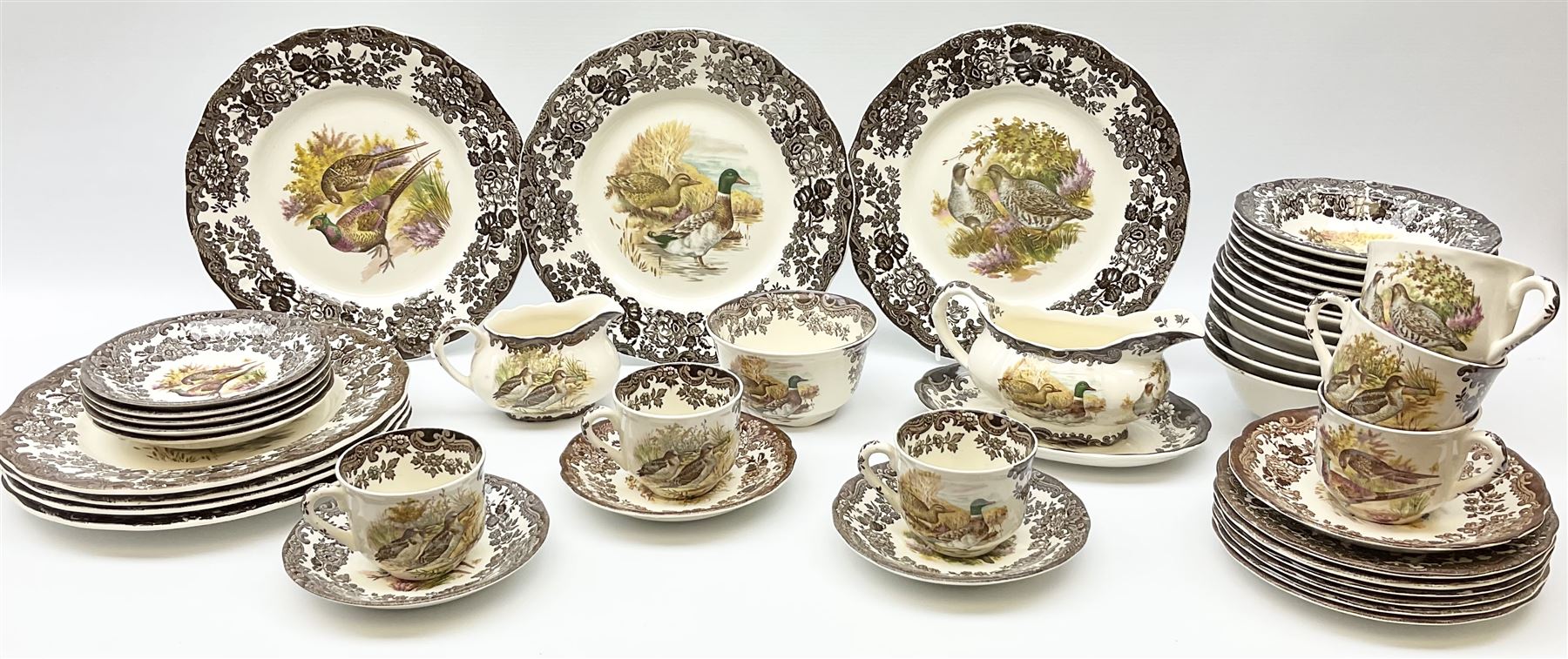 Royal Worcester Palissy Game Series pattern dinner wares, comprising seven dinner plates, six side plates, twelve bowls, sauce boat and stand, six tea cups, eight saucers, further larger saucer, milk jug, and open sucrier. 