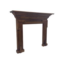 Victorian stained pine fire surround, projecting cornice with dentil moulding, panelled frieze and chamfered uprights on block supports