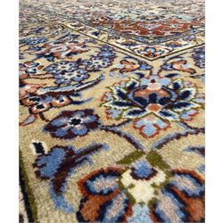 Central Persian Najafabad hand-knotted carpet, the ivory field with a central floral medallion radiating palmettes and arabesques in tones of blue, lilac and tan, enclosed by a wide navy border of scrolling vine and rosette motifs, with red spandrels and multiple guard stripes