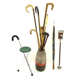 Two smooth polished ram horn handled Shepherd's crooks and a further similar example, together with various shooting sticks, walking sticks and canes, housed in a volcanic lava glaze West German style vase