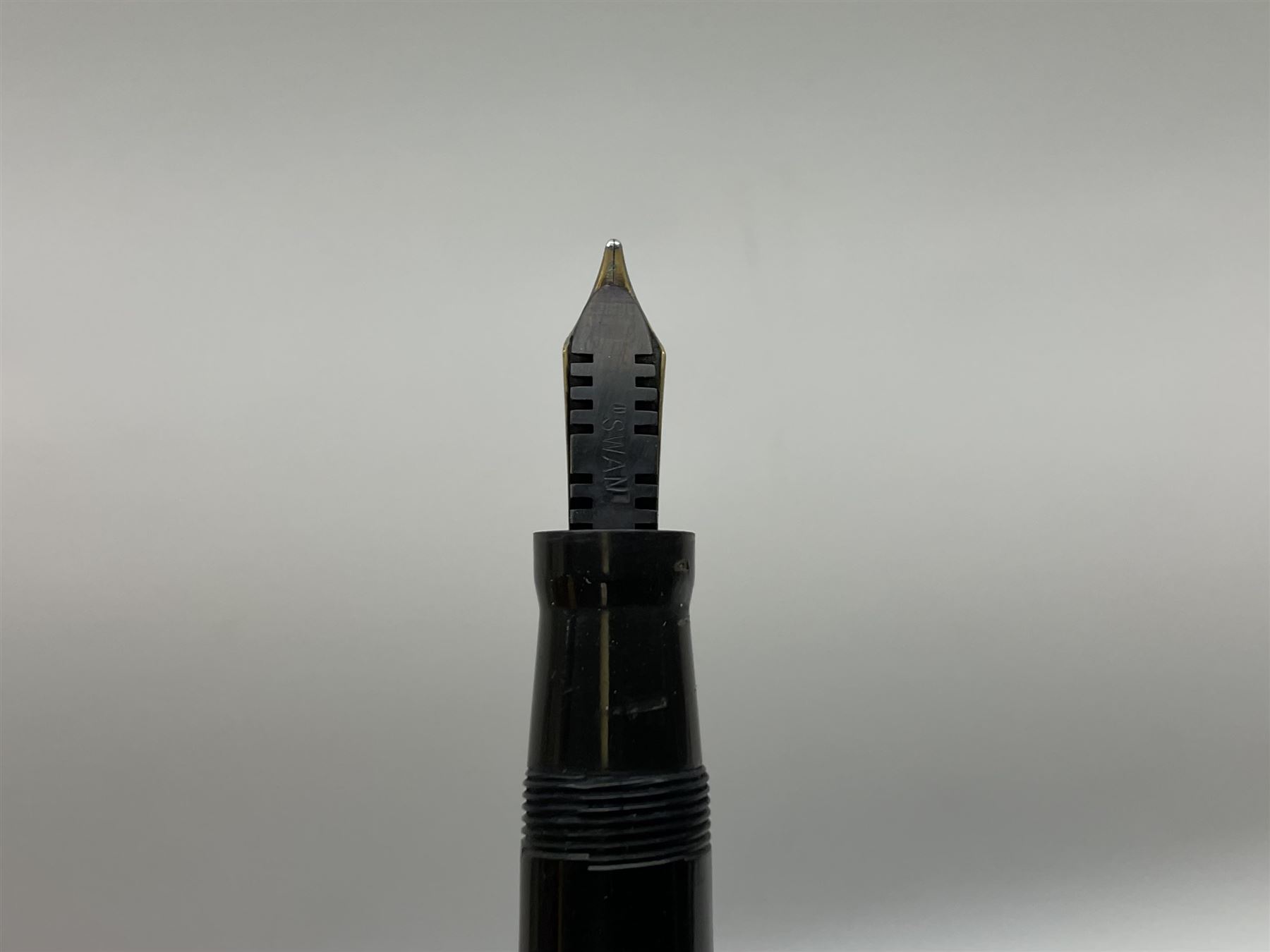 Vintage Swan Mabie Todd lever fill fountain pen in coral red, the nib a/f marked 14K, together with two further vintage Swan Mabie Todd fountain pens, the first example with lever fill, the other leverless, each with black body, one with nib marked 14ct, (3) 