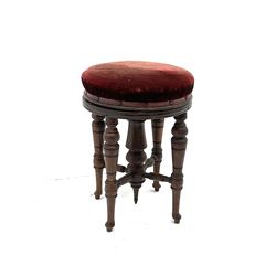 Mahogany swivel stool, seat upholstery in a wine red fabric, turned supports and stretchers