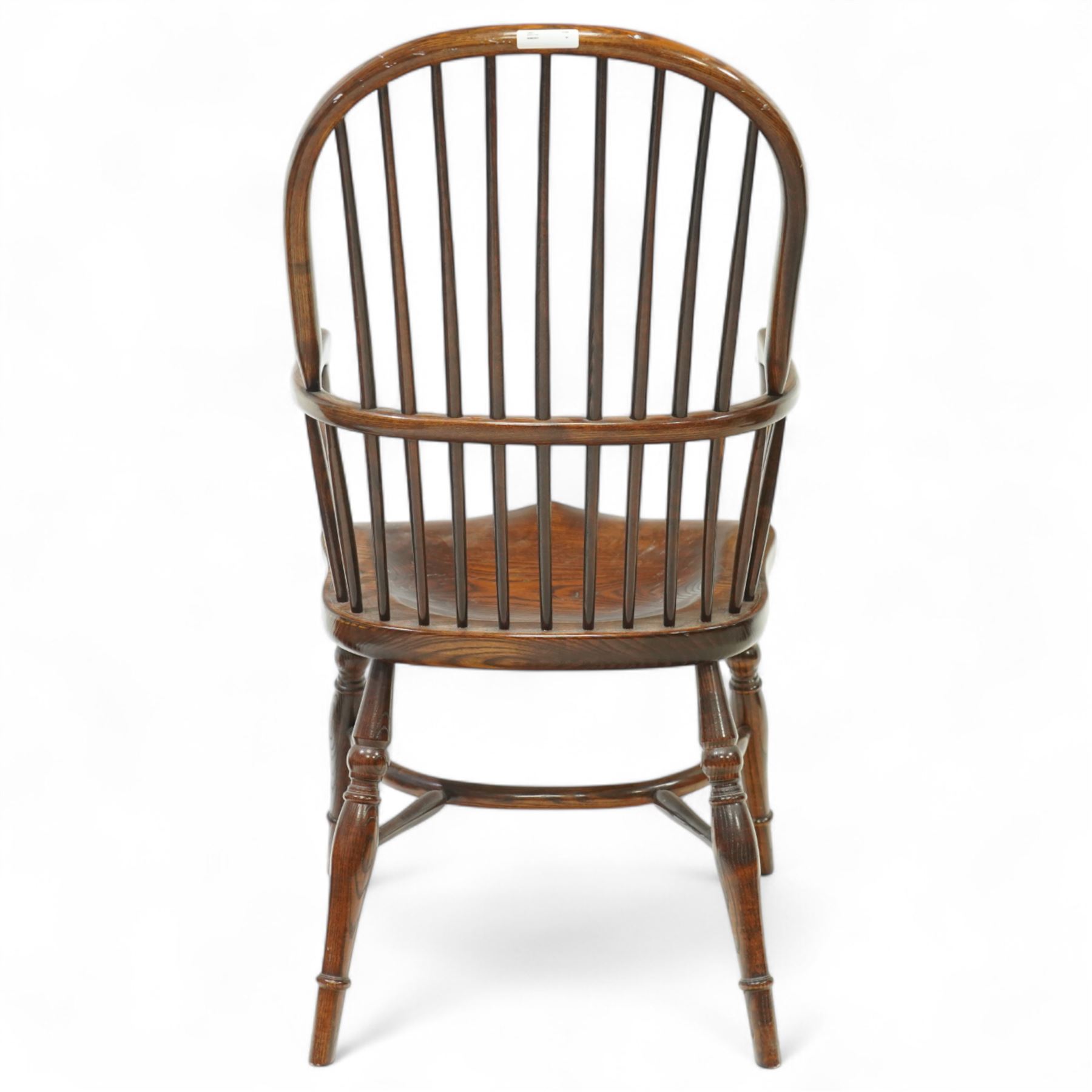 Late 19th century ash and elm Windsor armchair, with hooped back and spindle supports, shaped elm saddle seat, on turned legs united by crinoline stretcher