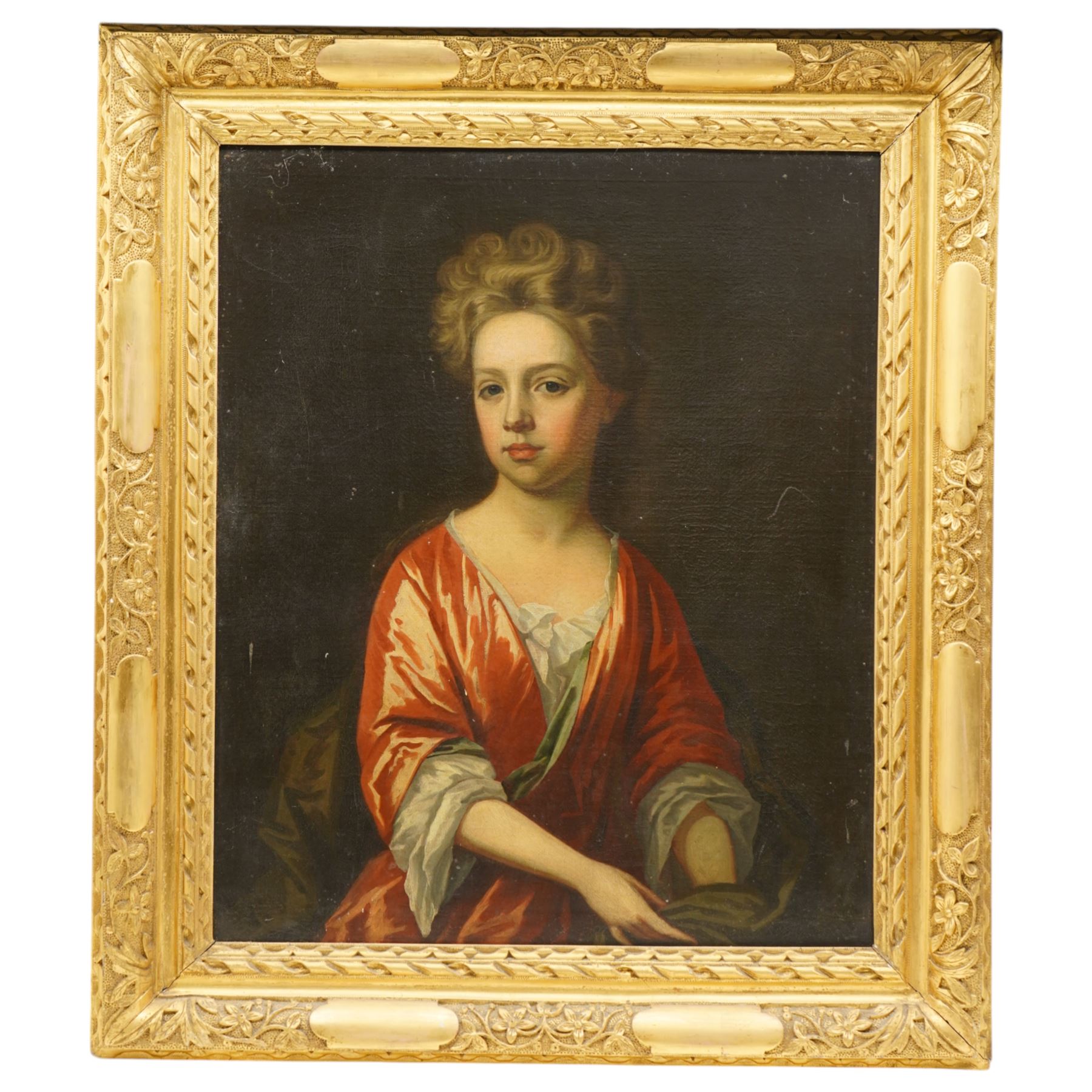 Follower of Sir Godfrey Kneller (German/British 1646-1723): Portrait of a Girl Wearing a Satin Pink Dress, 18th century oil on canvas unsigned 73cm x 61cm, housed in heavy gilt foliate moulded frame, overall 95cm x 83cm