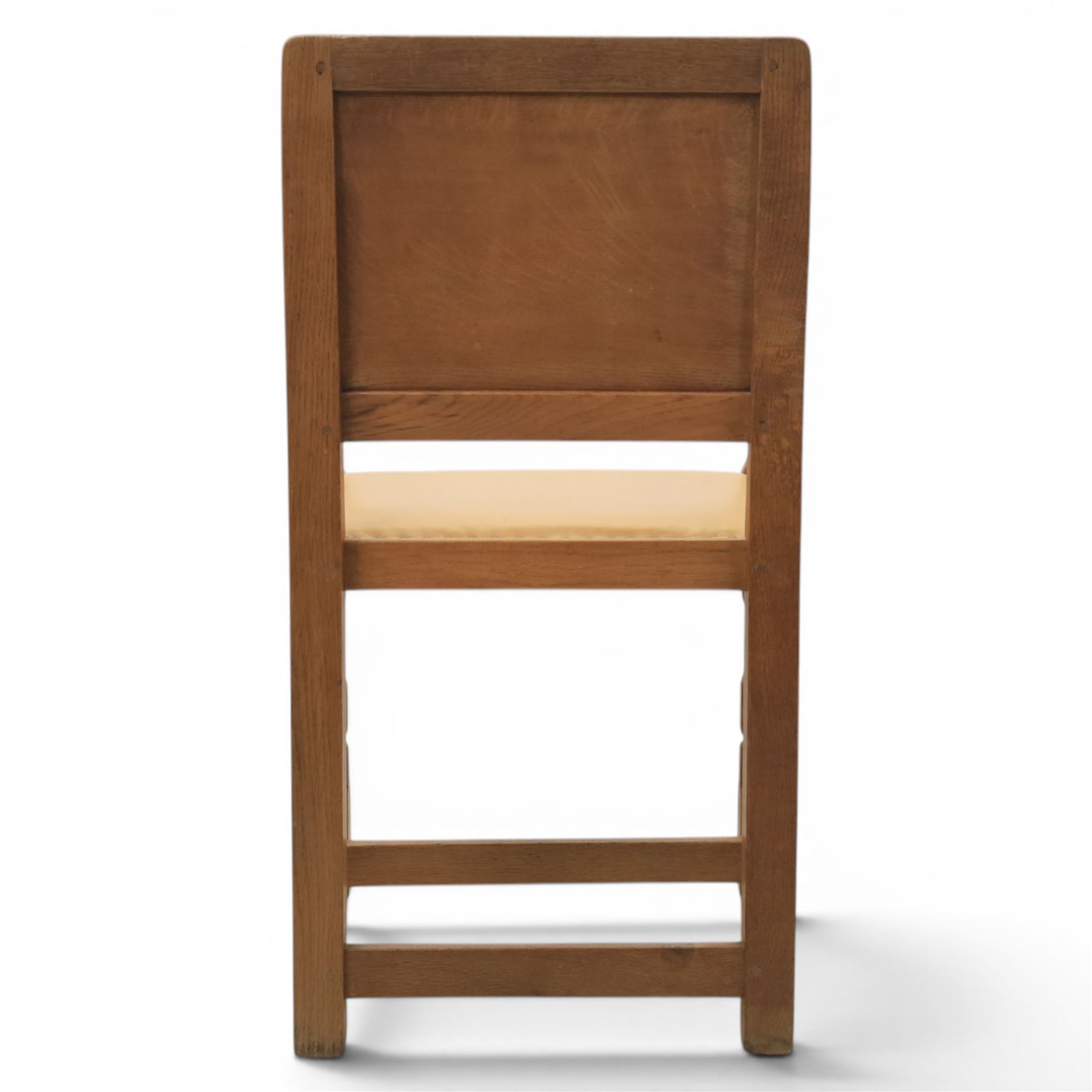 Mouseman - oak panel back carver armchair, with commemorative back panel engraved 'In memory of Fiona Mary Fotheringham Born 5th June 1958 Died 14th July 1965', above tan seat with brass studded trim, with carved Mouse signature, by Robert Thompson's of Kilburn