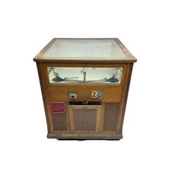 Early to mid-20th century arcade prize machine game, glazed top and sides enclosing circular rotation disk with moveable arms, and prize-drop slots