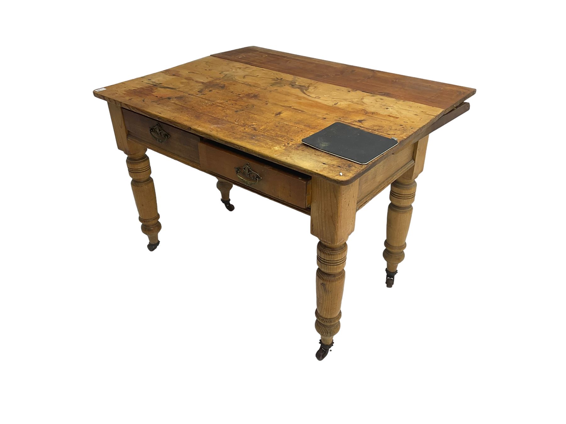 Traditional rustic pine dining table, rectangular top fitted with two drawers, raised on turned tapering supports on ceramic castors