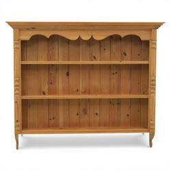 20th century country style waxed pine hanging wall shelf, with projecting cornice, over three fixed delf racks, flanked by applied turned columns, with brass wall hangers