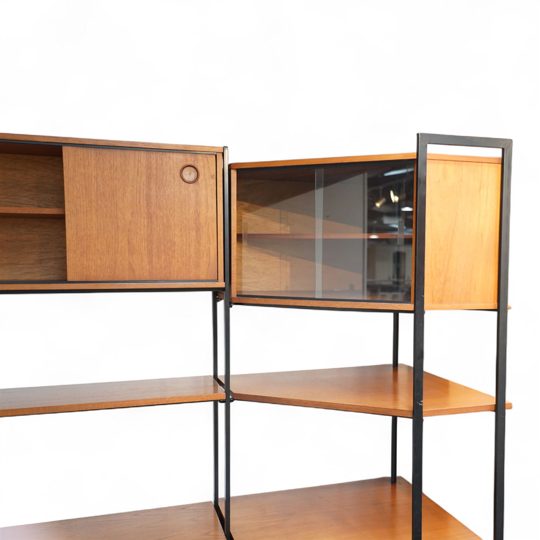 Avalon - modular teak wall unit, with black metal supports, fitted with cupboards, drawers, and adjustable shelves, corner configuration