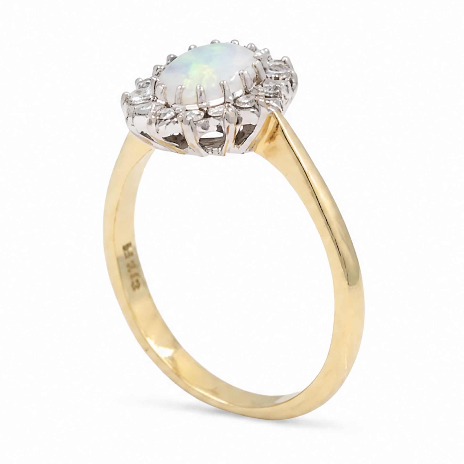 18ct gold opal and diamond cluster ring, single oval cabochon cut opal, surrounded by fourteen round brilliant cut diamonds, London 1988, total diamond weight approx 0.30 carat