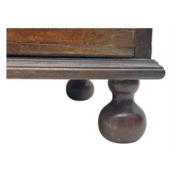 George III oak bureau, sloped fall-front enclosing a fitted interior with pigeonholes, small drawers, and a central compartment, over two short and two long drawers, brass escutcheons and drop handles, raised on bun feet