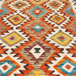 Afghan kilim ivory ground runner rug, the field with three columns of repeating lozenge motifs with amber and multicoloured tones, enclosed by a guard band decorated with repeating stylised hooks