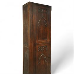 19th century Gothic Revival oak Sacristy vestment cupboard of tall proportions, fitted with two ecclesiastical trefoil moulded panelled doors enclosing four shelves, flanked by a chamfered corner, the side panelled and moulded with matching sacristic architectural mouldings, on skirted base