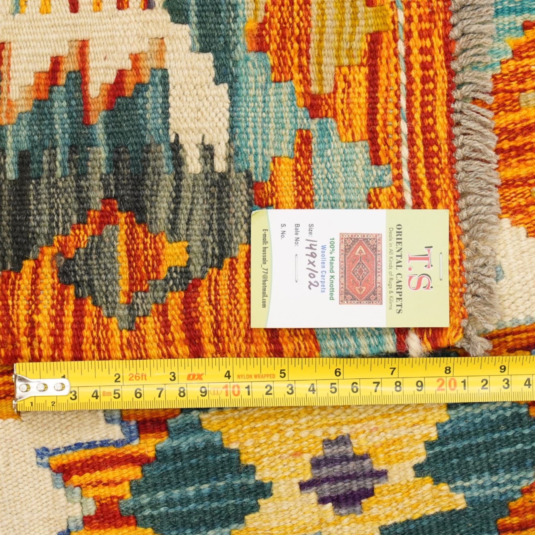 Afghan Chobi kilim flatweave runner with a repeating stepped diamond medallion design in live green, rust, teal, purple, and ivory, framed by chevron and geometric borders