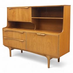 Sutcliffe of Todmorden - Mid 20th century teak highboard, ‘S-Form’ range, the upper section with glazed and panelled sliding doors above open shelving, over a base fitted with twin drawers and cupboards, all with moulded recessed handles, on shaped tapering supports, reflecting the sleek organic styling characteristic of 1960s British modern furniture design