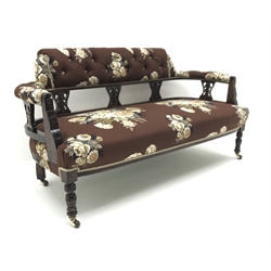  Late Victorian walnut framed settee, button upholstered in vintage Sanderson Langley fabric with floral bouquets on chocolate ground, open carved wasted splat, incised front rail with matching turned supports on brass fork ceramic castors, W144cm  