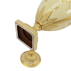 Royal Crown Derby twin handled vase and cover, circa 1886, decorated with raised and tooled gilt borders of foliate scrolls and husk swags upon a cream ground, H38cm