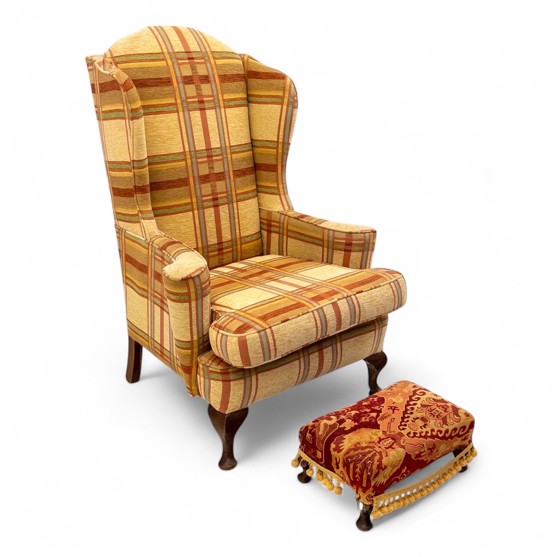 20th century Georgian style upholstered wingback armchair with footstool, the chair in yellow and red plaid fabric, the stool with fringed tapestry cover