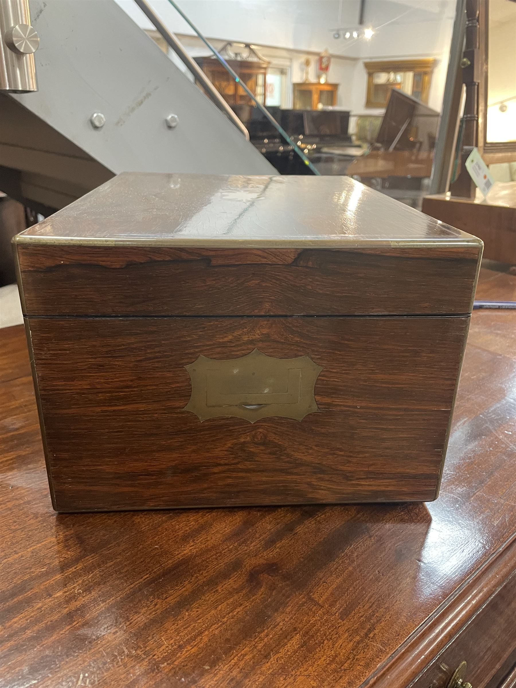  Victorian brass inlaid rosewood dressing table box, retailed by F.L. Hausburg, Liverpool, the lid centred by a brass cartouche, opening to reveal letter store to lid underside, above a fitted interior, with ten mounted cut glass jars, bottles and manicure set, within lift out leather trays, above jewellery drawer, with key, H17cm D24cm