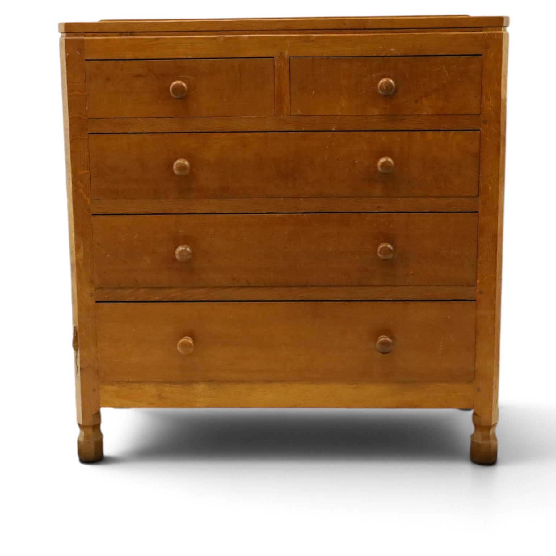 Mouseman - early-to-mid 20th century adzed and panelled oak chest, raised back over rectangular adzed top with canted corners, fitted with two short over three long drawers with turned knob handles, raised on octagonal feet, with carved mouse signature, by the workshop of Robert Thompson of Kilburn