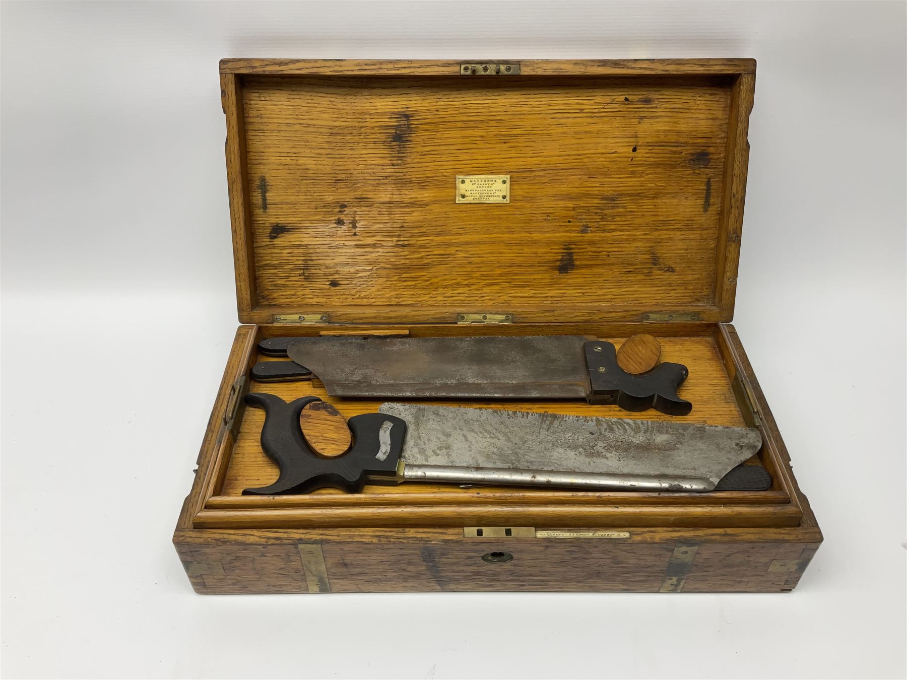 Naval doctor's surgical instruments, contained in a converted brass bound oak pistol box, the hinged lid opening to reveal two removable fitted trays, containing 19th century and later saws, scalpels, tweezers etc