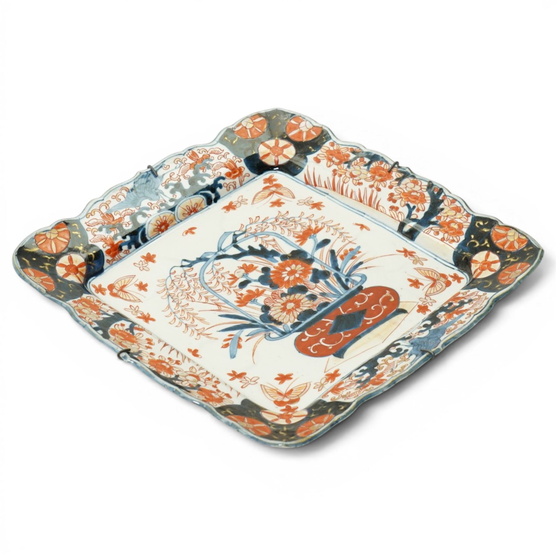 Late 19th/early 20th century Japanese Imari square dish decorated with flowers 32cm and an Indian linen wall hanging decorated with elephants, carriages etc in procession 56cm x 170cm