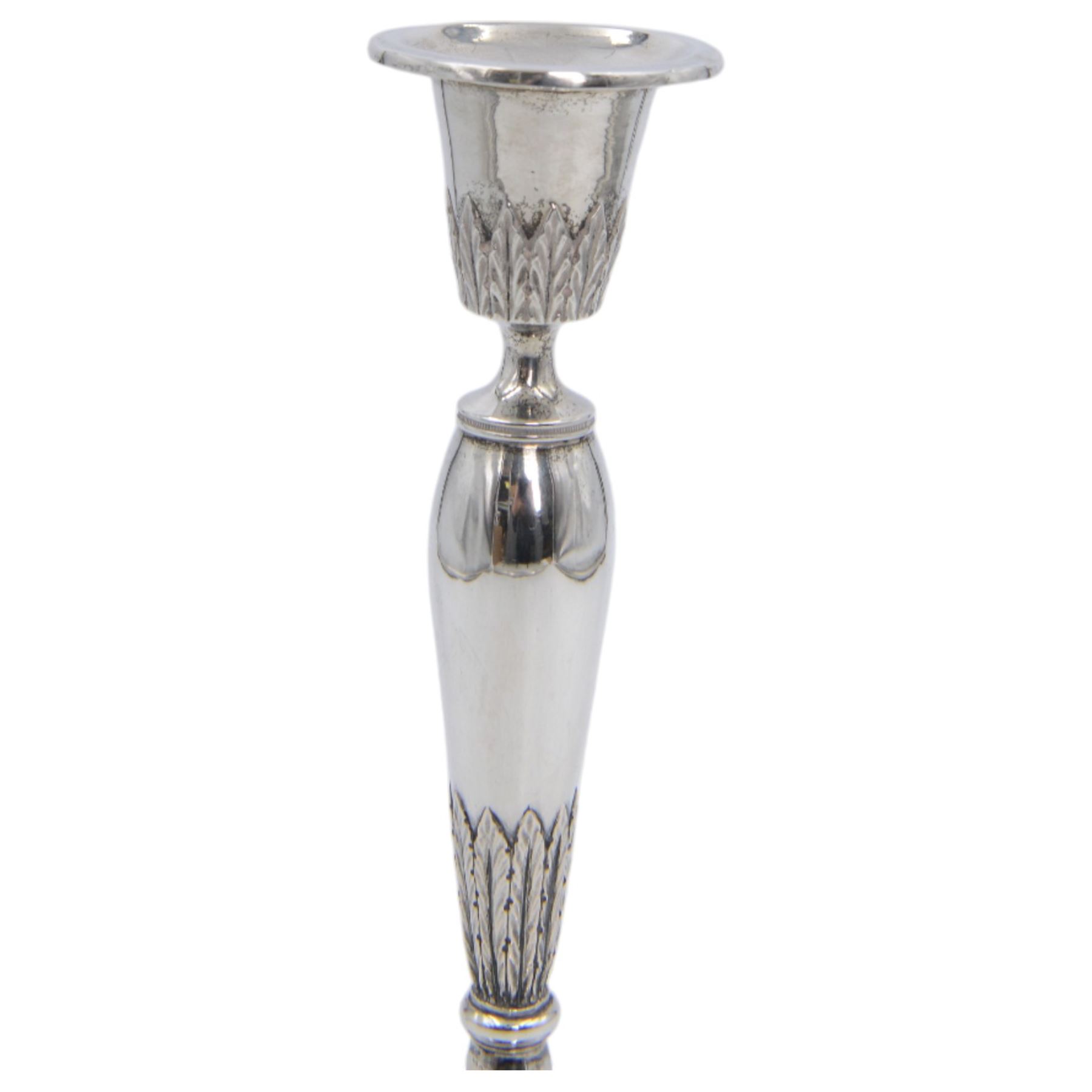 Pair of continental silver candlesticks, probably German Hanau, each of tapering form, with fern leaf decoration, upon a stepped circular base, with Hanau marks and assay scrape to base, H19cm