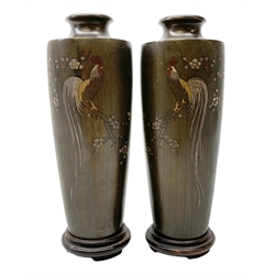 Pair of Meiji Period Japanese bronze vases, c1900, of slender baluster form, each inlaid with various metals with a cockerel perched upon a blossoming branch, incised character mark to bodies, with hardwood stands, vases H18.5cm