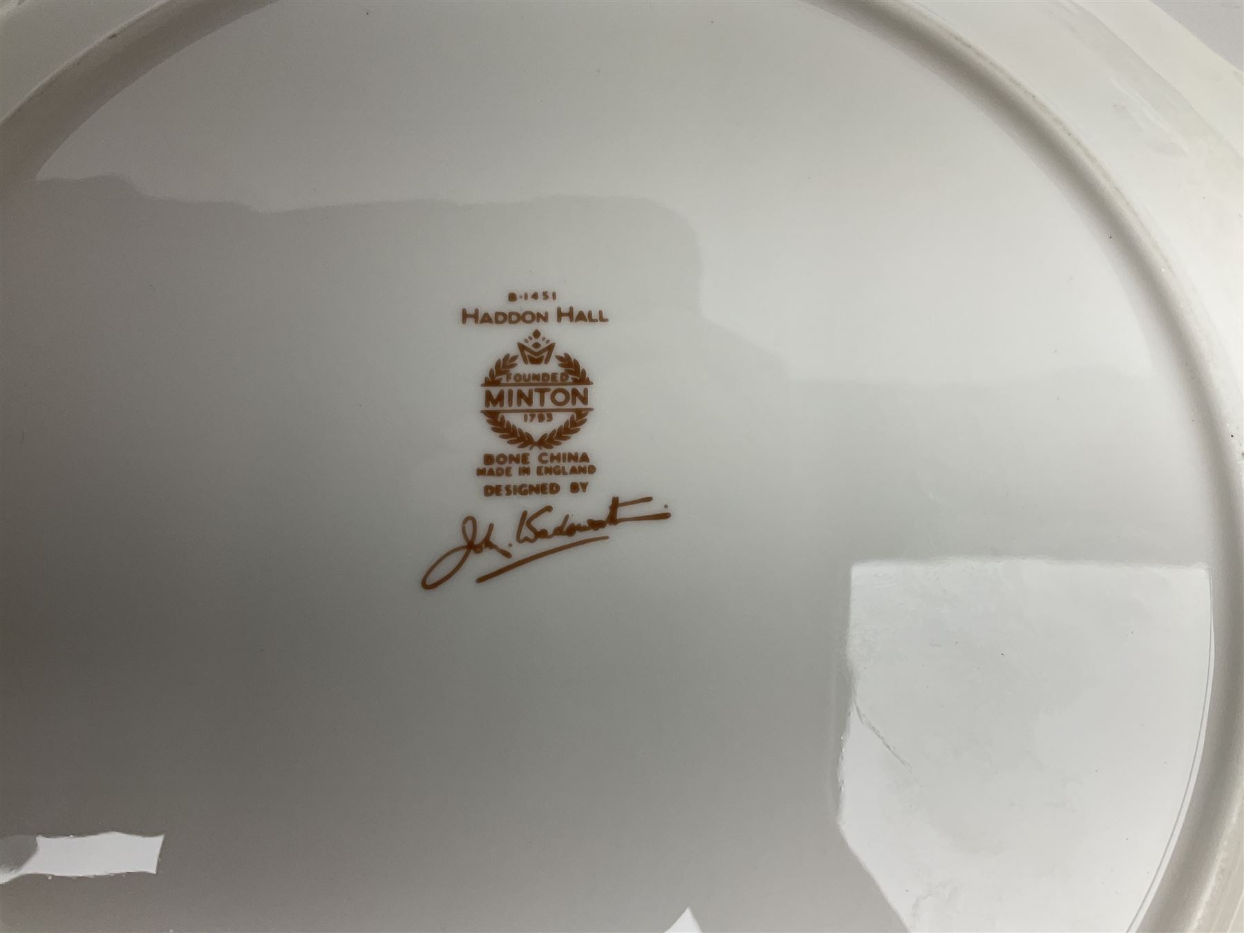 Minton Haddon Hall pattern tea and dinner wares, including basket dish, two covered tureens, six dinner plates, eight dessert plates, twelve tea plates, six soup bowls, six cereal bowls, teapot, coffee pot, milk jug, covered sucrier twelve tea cups and saucers, six mugs, footed bon bon dish, pair of candlestick holders, cake knife and slice etc (81)