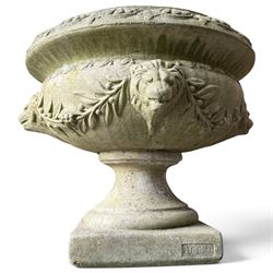 Regency design weathered cast stone garden urn of kylix form, the anthemion and arrowhead moulded everted rim over a fruiting laurel and lion-mask relief decorated body, waisted socle on square base, stamped HGC