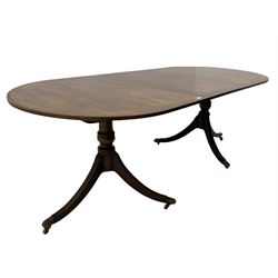Regency style mahogany twin pedestal dining table, crossbanded border with brass inlay, with leaf