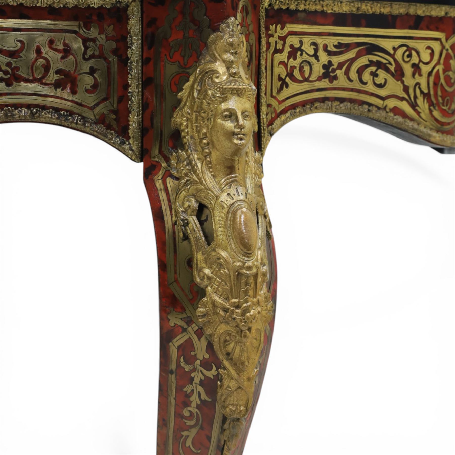 Late 19th century boulle work centre table, shaped serpentine top decorated with brass inlay on red tortoiseshell ground within ebonised border, fitted with single frieze drawer, on cabriole supports with gilt metal mounts and mask terminals
