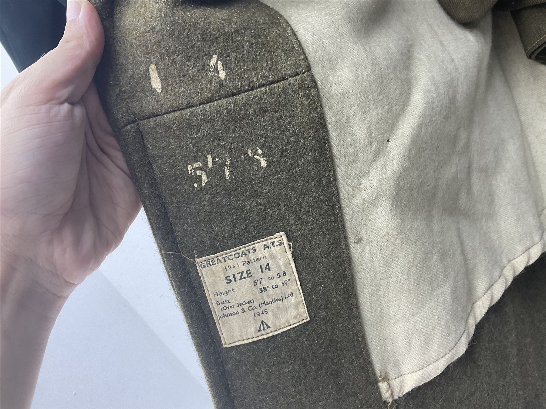 WW2 British female ATS Sergeant's service uniform grouping, consisting of four pocket female pattern service dress tunic with brass ATS shoulder titles and general service buttons; cloth lined interior with the original printed size label dated 1942; the matching khaki service dress skirt; and Greatcoat with size label dated 1945; together with army knitted sleeveless V-neck jumper; WRAC tunic, skirt and overcoat; full length cream and gold thread military evening dress by Hilliers Couture; and four webbing belts