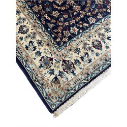 Persian indigo ground rug, the central pointed pole medallion surrounded by scrolling garlands, the guarded ivory border decorated by repeating foliate motifs