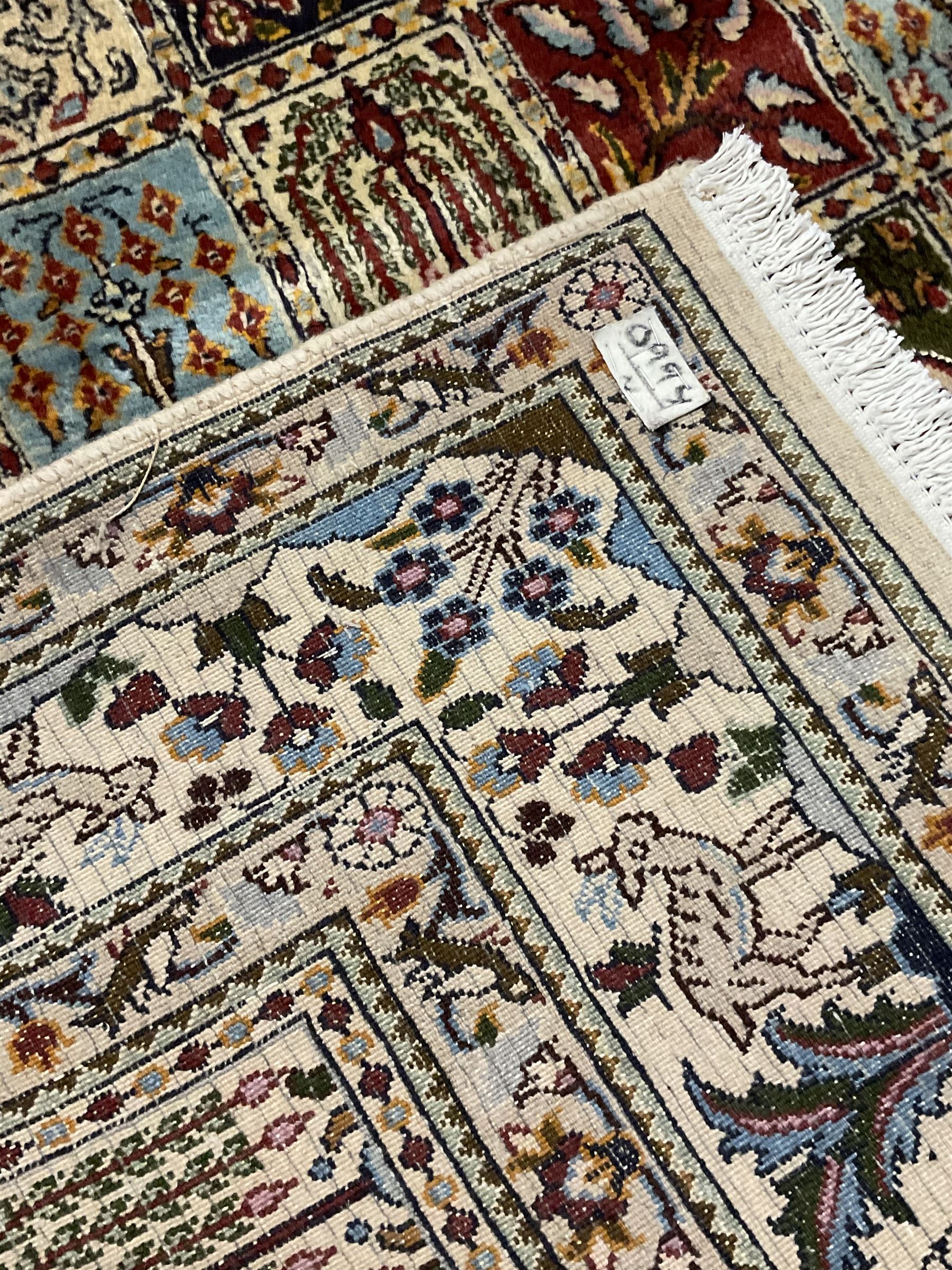 Persian Heriz design rug, ivory ground with rectangular panels each depicting garden scenes of tree of life, plants and Boteh motifs, the guarded border decorated with wildlife and bird scenes