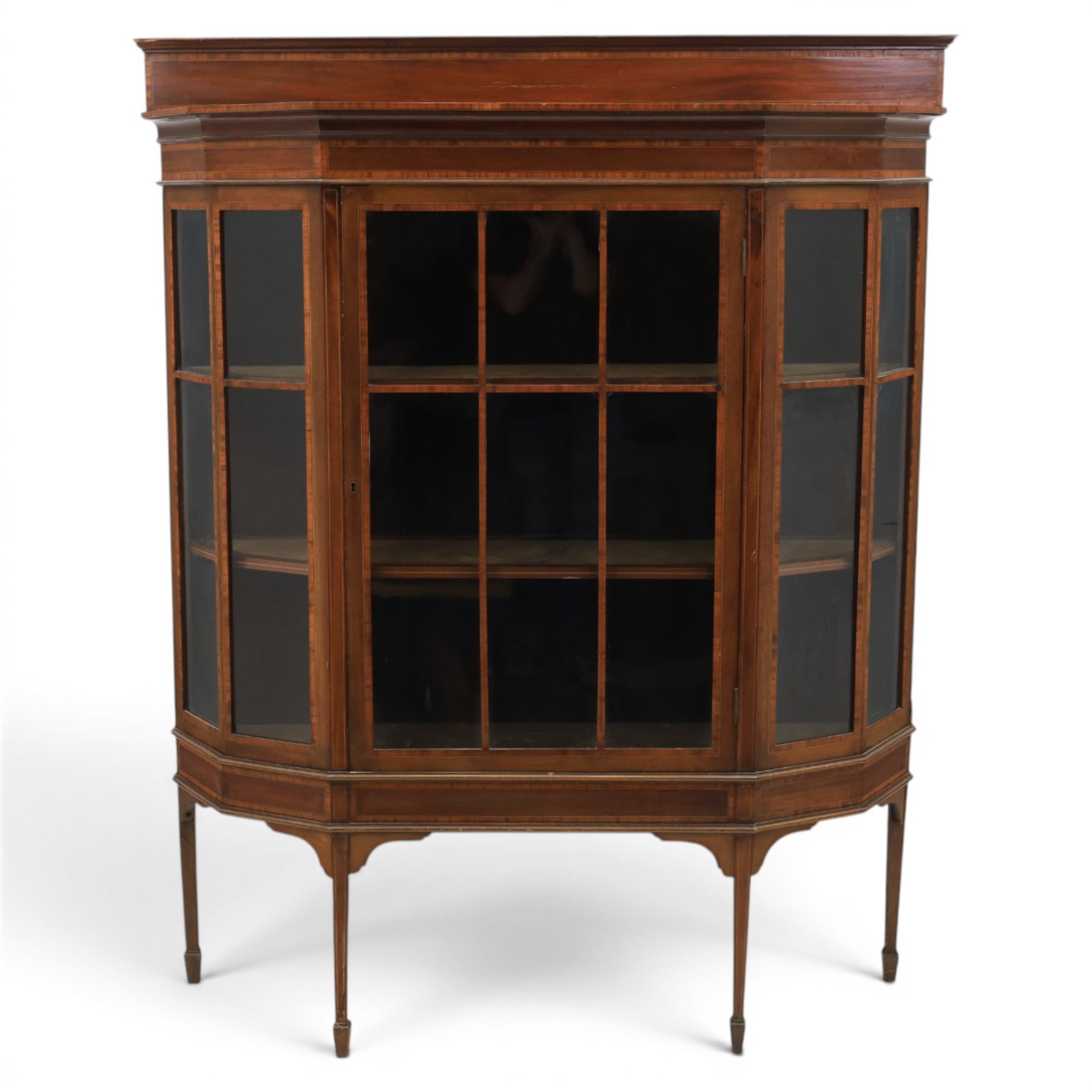 Edwardian inlaid mahogany display cabinet of rectangular canted form, galleried top with crossbanded inlay, above a glazed cabinet enclosing  baize lined shelves, raised on square tapering legs terminating in spade feet  