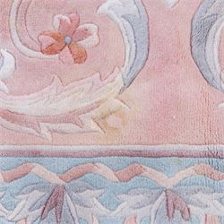 Large late 20th century Aubusson style wool carpet, peach and pastel toned field with central floral medallion enclosing scrolling acanthus and and foliate sprays, surrounding field decorated with further stylized foliage and and floral ornament, within shaped reserves and indigo corner spandrels, enclosed by narrow guard border, cotton fringe ends