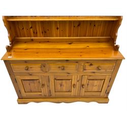 Pine farmhouse dresser with three drawers and three cupboards, and two tier plate rack