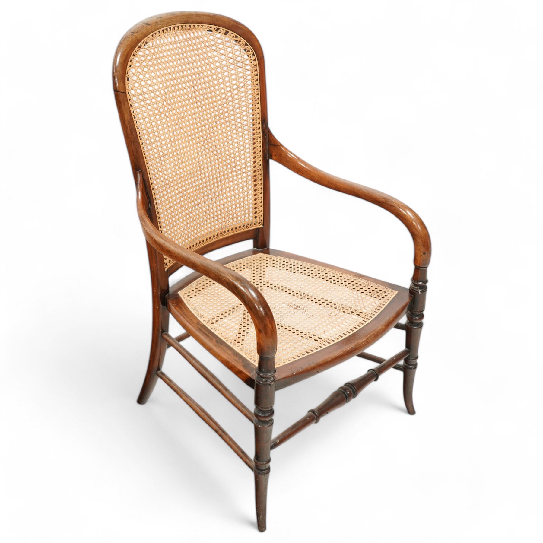 Victorian stained beech frame open armchair, arched cane work back and seat, on turned supports with splayed feet united by turned stretchers 