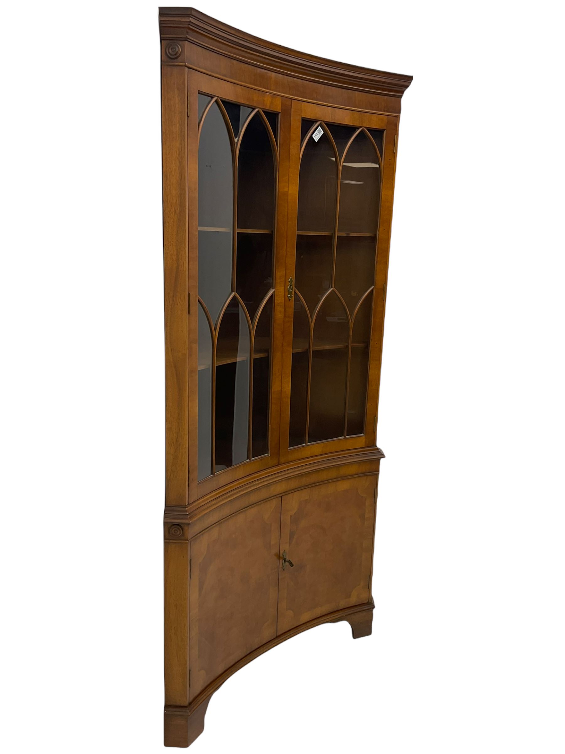 Late 20th century Georgian design mahogany concave corner display cabinet, enclosed by two curved astragal glazed doors, double cupboard below, on bracket feet