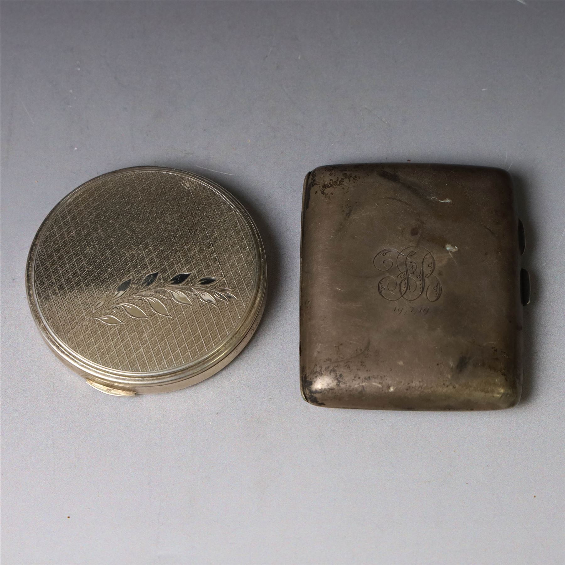 1960s silver compact mirror, of circular form with engine turned and engraved foliate decoration to lid, hallmarked Kigu Ltd, London 1963 and an early 20th century silver cigarette case with engraved monogram to cover, hallmarked A J Pepper & Co, Birmingham 1918