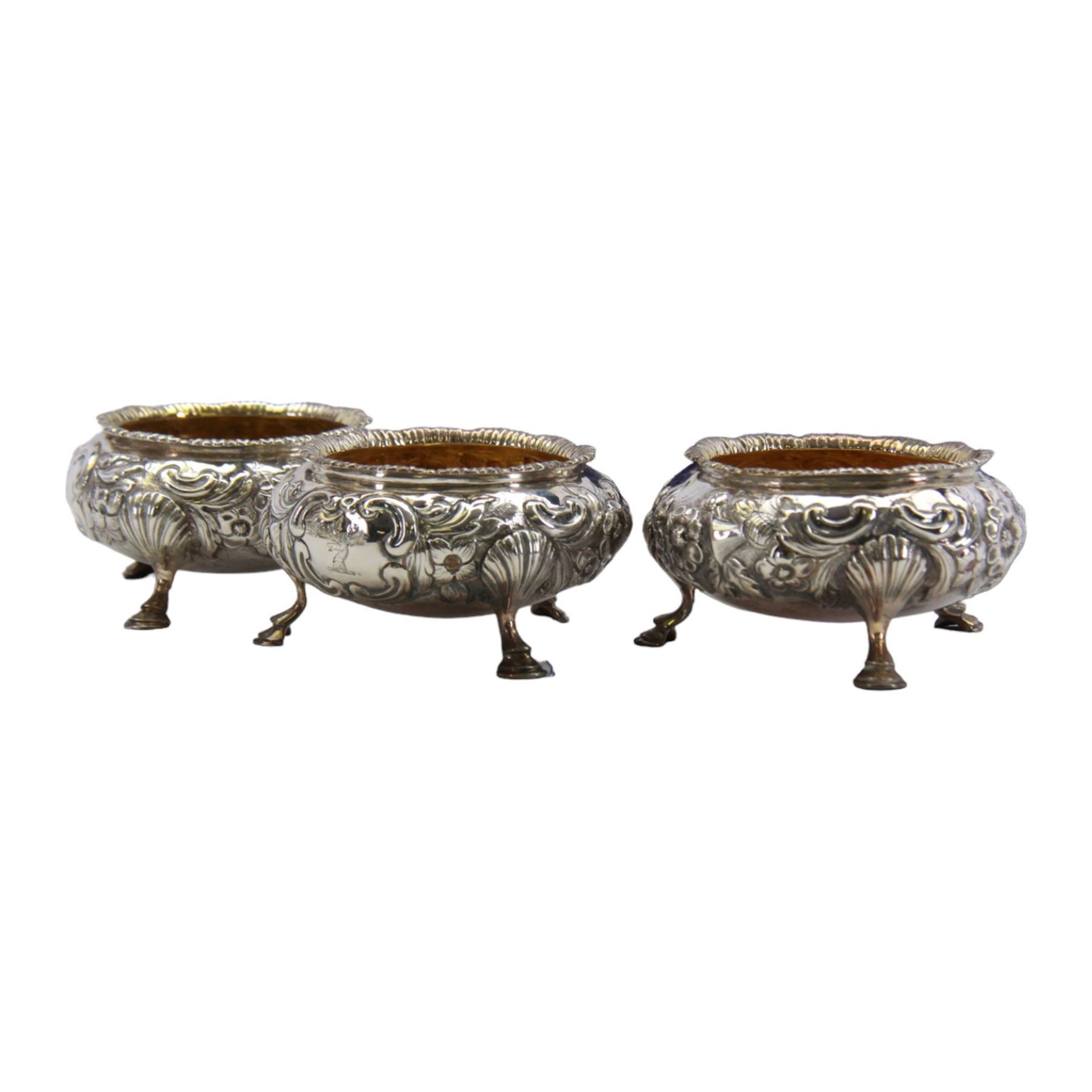 Cased set of four Victorian silver open salts, each of cauldron form with embossed foliate decoration, gadrooned rim and gilt interior, upon three hoof feet, hallmarked William Hunter, London 1844, H4cm, together with four earlier Georgian salt spoons, hallmarked London 1800, makers marks worn and indistinct, contained within a fitted case with velvet and silk lined interior
