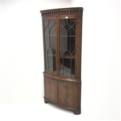Bevan Funnel Reprodux mahogany double corner cabinet, projecting cornice, dentil frieze, two astragal glazed doors enclosing two shelves above single slide, two cupboard doors, bracket supports 