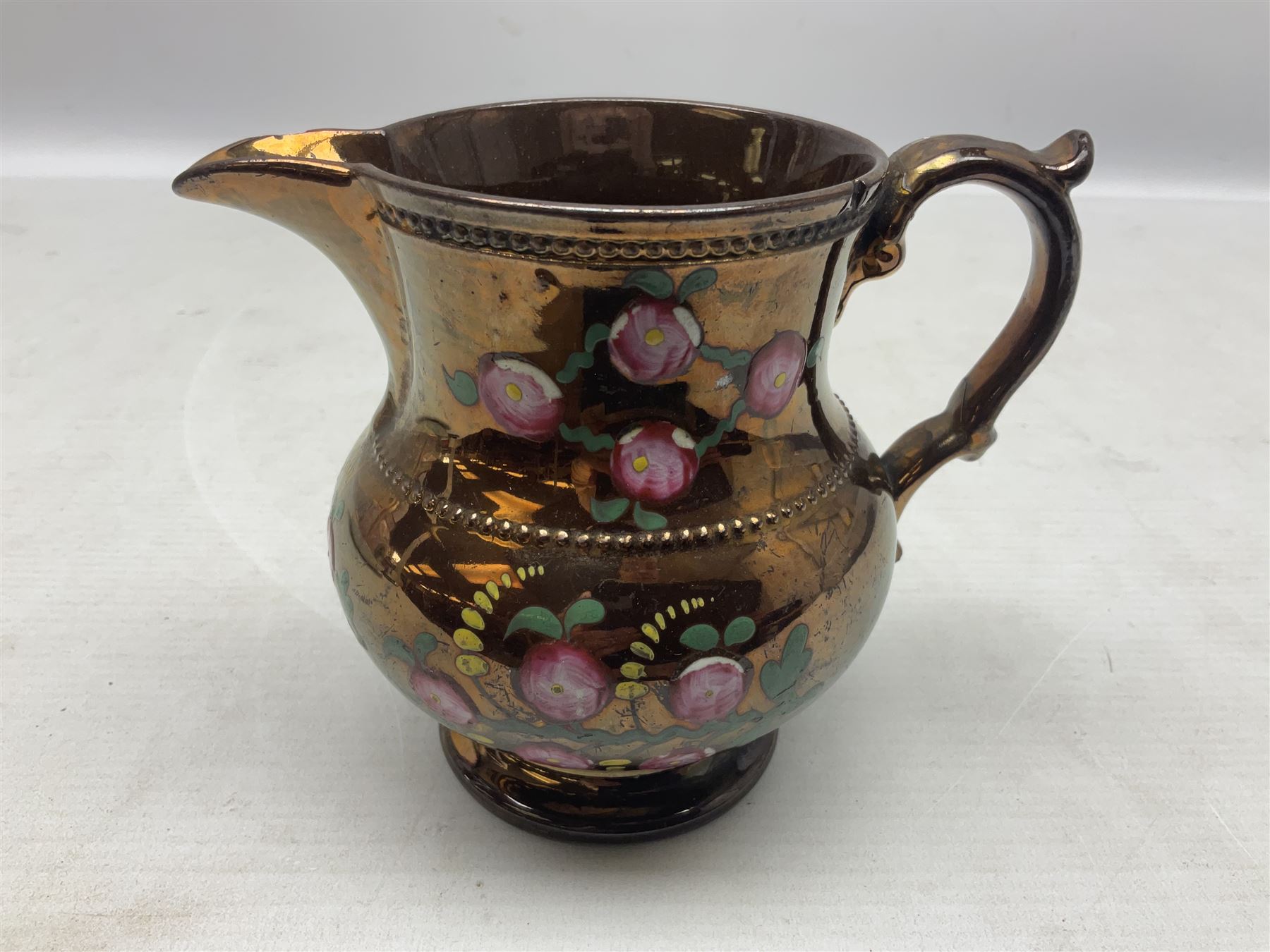 Early 20th century Sunderland lustre jug, decorated with transfer Masonic scene and poem 'The World is in Pain/Our Secrets to Gain/But Still Let Them Wonder and Gaze/The Never Can Divine/The World Nor The Sign/Of a Free and Accepted Mason', the reverse decorated with Sunderland River Wear cast iron bridge scene below text (a/f), together with a copper lustre jug, and pink lustre bowl, jug H20cm