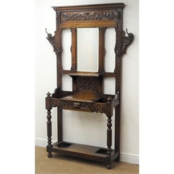  Victorian carved oak hall stand, raised bevel edge mirror back, turned supports joined by a single undertier with two metal umbrella trays, W122cm, H199cm, D32cm  