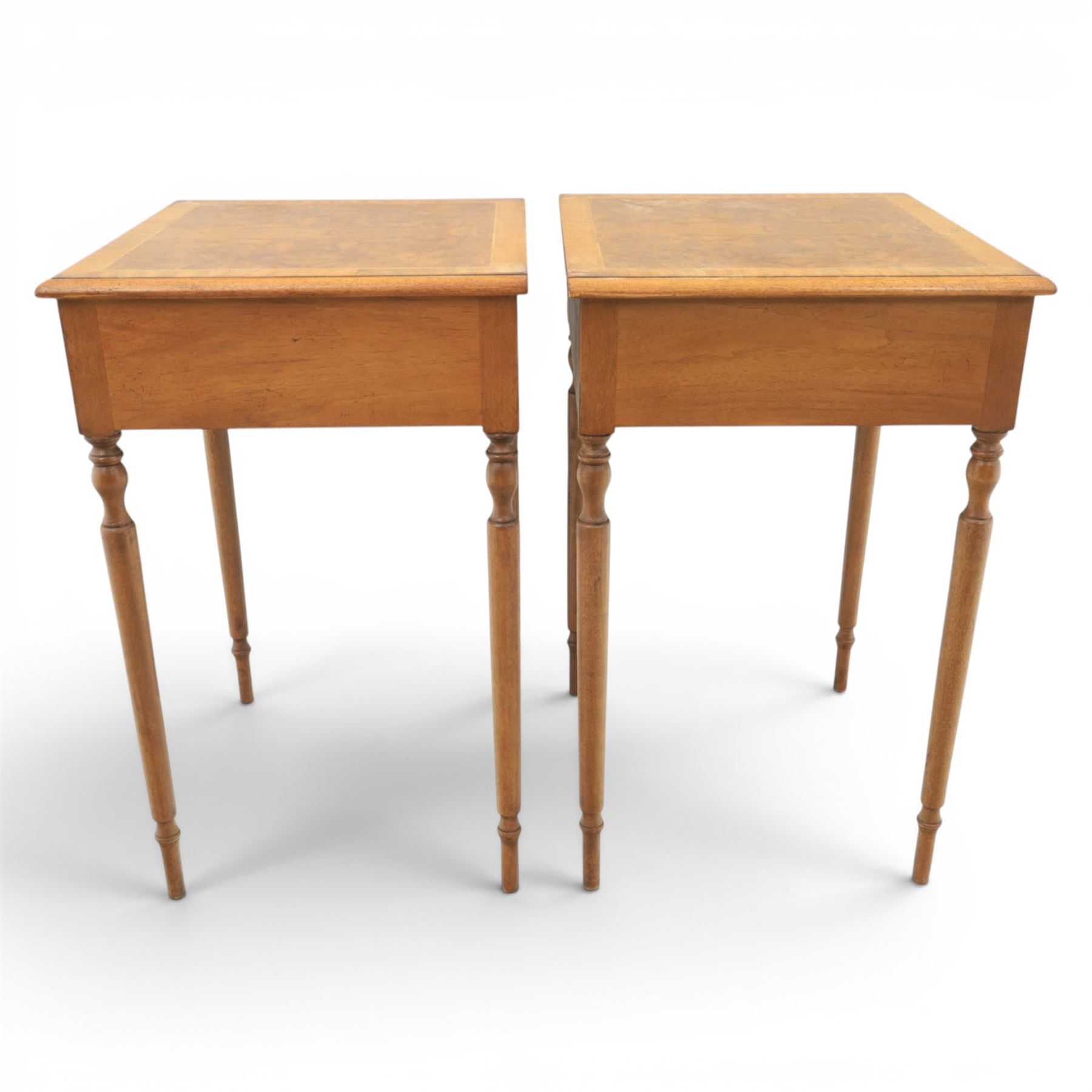 Traditional design pair of walnut lamp tables, figured top with crossbanded edge, above a single frieze drawer with brass oval handles, raised on turned supports