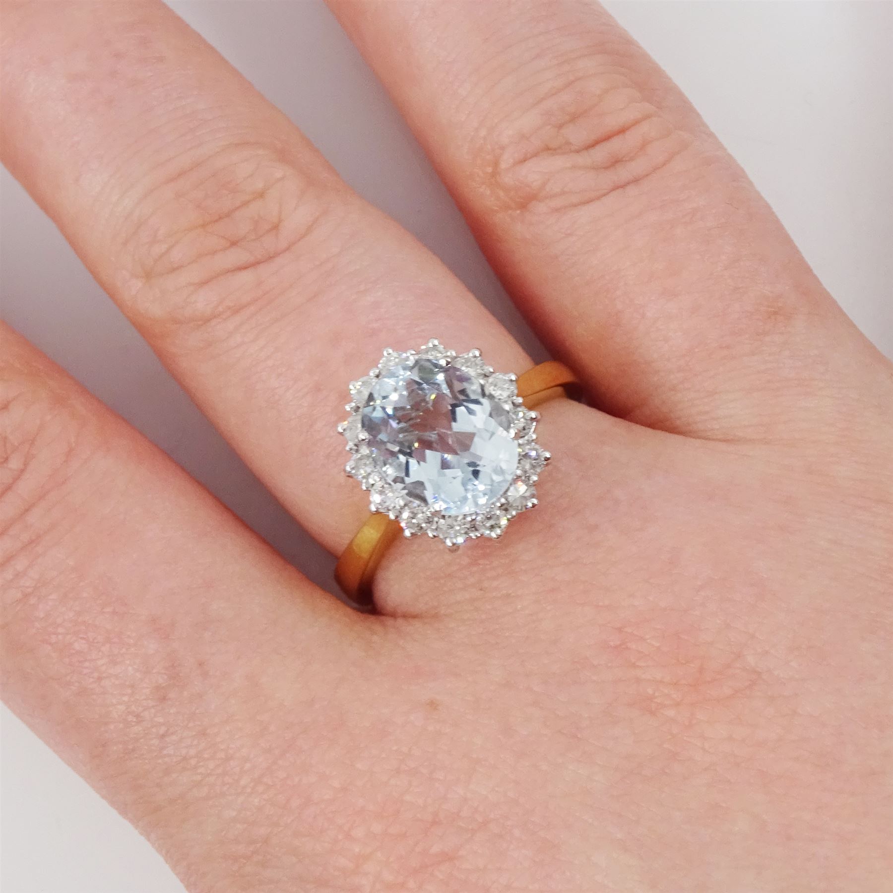 18ct white gold aquamarine and diamond cluster ring, single oval cut aquamarine of approx 2.30 carat, surrounded by fourteen round brilliant cut diamonds, London 2022, total diamond weight approx 0.45 carat