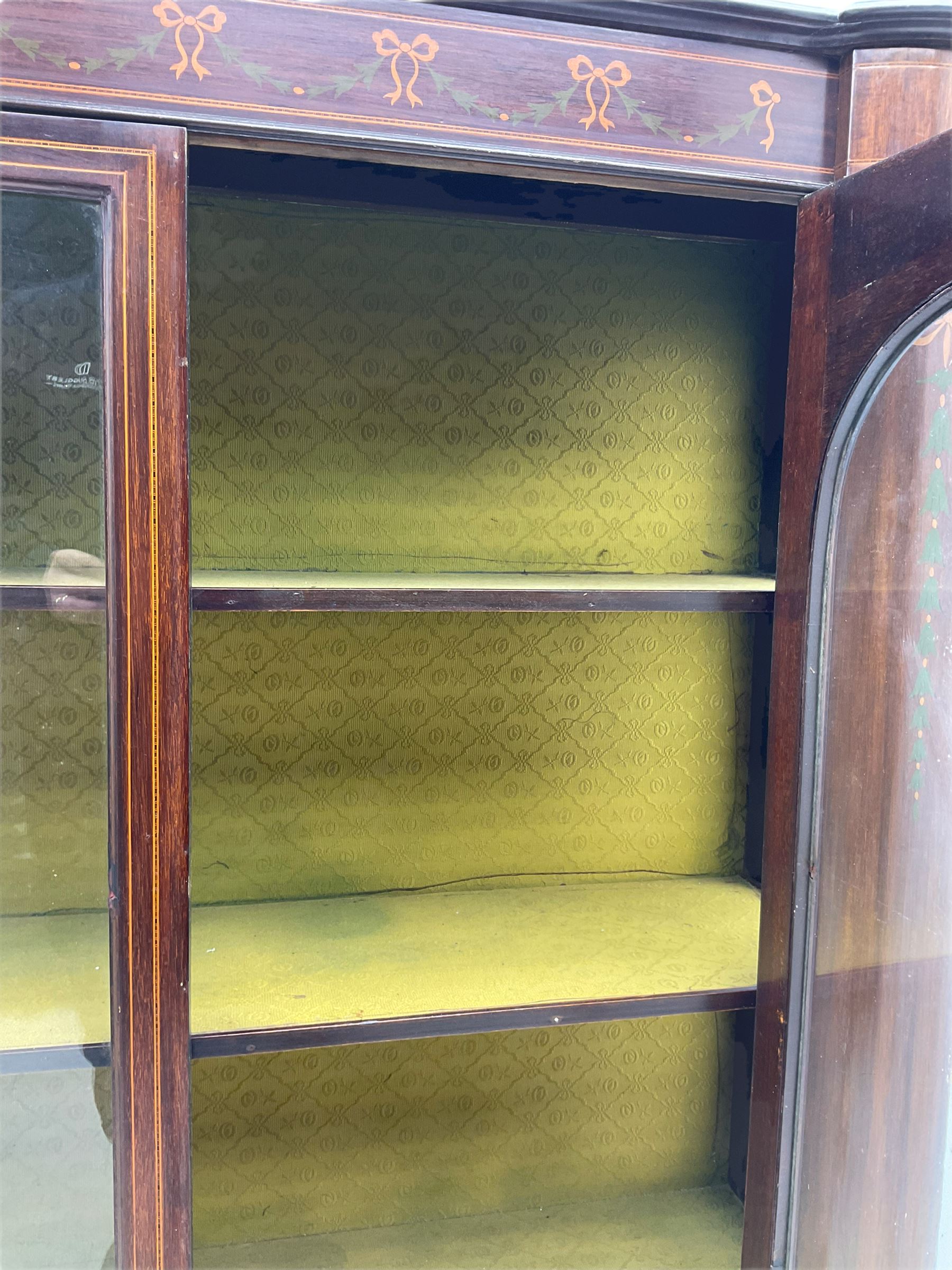 Edwardian mahogany display cabinet, shaped front with painted ribbon and bellflower garland decoration, enclosed by two glazed doors, cabriole supports
